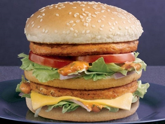 Chicken Maharaja Mac: A Índia é talvez o destino com os lanches do McDonald's mais originais: no país das vacas sagradas, não espere encontrar lanches feitos com a carne do animal nos restaurantes locais. Por isso, é o frango que domina as receitas do McDonald's por lá, com destaque para o Chicken Maharaja Mac, a resposta indiana para o Big Mac. O lanche leva dois hambúrgueres de frango, salada e um molho especial defumado - Divulgação/McDonald´s