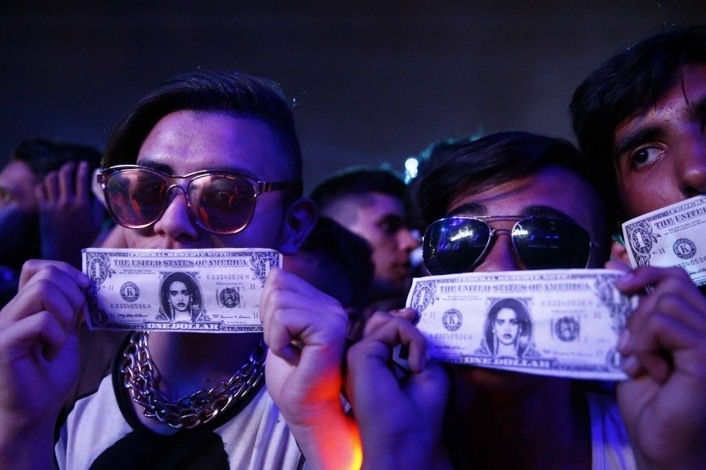 26.set.2015 - Fãs de Rihanna aguardam o início do show da cantora com notas de dólares com o rosto da diva pop - Marcelo Sayão/EFE