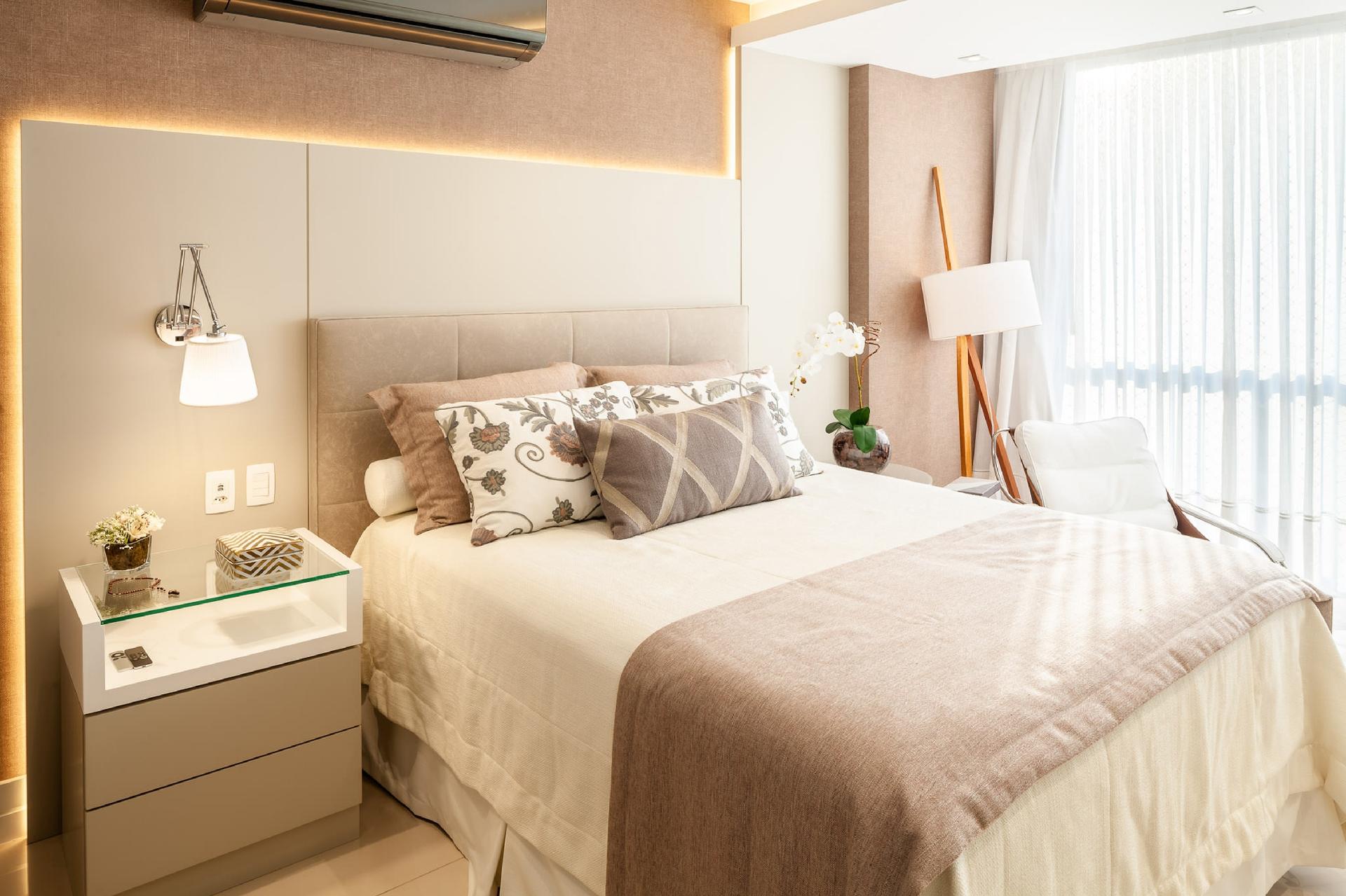 A cabeceira estofada de couro sintético traz conforto e praticidade na limpeza. Já o painel assimétrico de MDF laqueado recebeu esse formato em L para disfarçar um rebaixo de gesso. A placa complementa a cabeceira e recebeu uma iluminação embutida com fita de LED para valorizá-la e destacar o papel de parede. Projeto do escritório Campos & Olivetti - Dhani Borges/ Divulgação