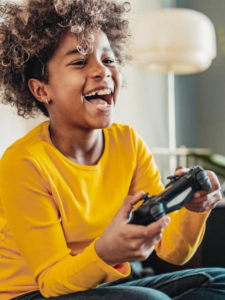Criança jogando videogame - blackCAT/iStock