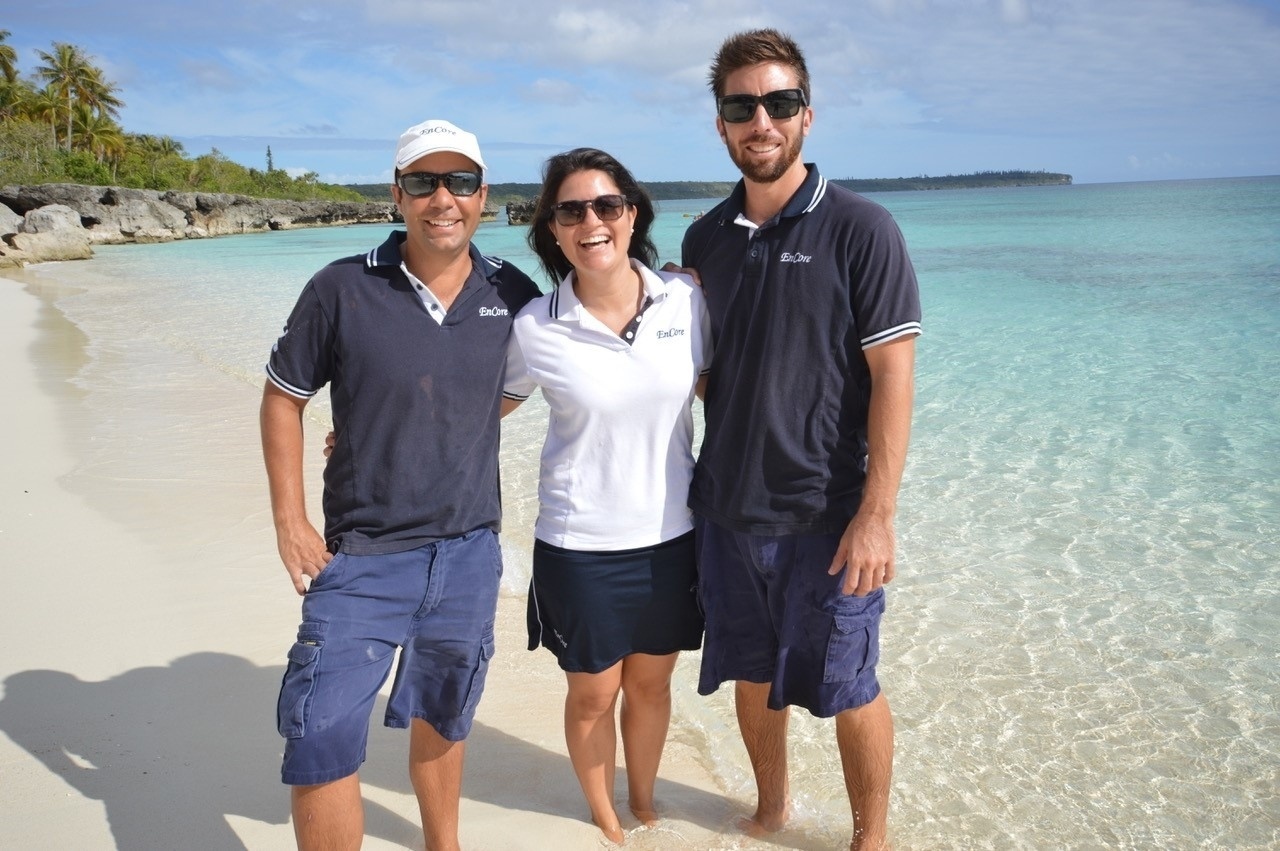 Na imagem, por exemplo, Sabrina está entre o capitão do iate e o chefe de cozinha. Eles estavam servindo o almoço para os convidados em uma praia - Arquivo pessoal