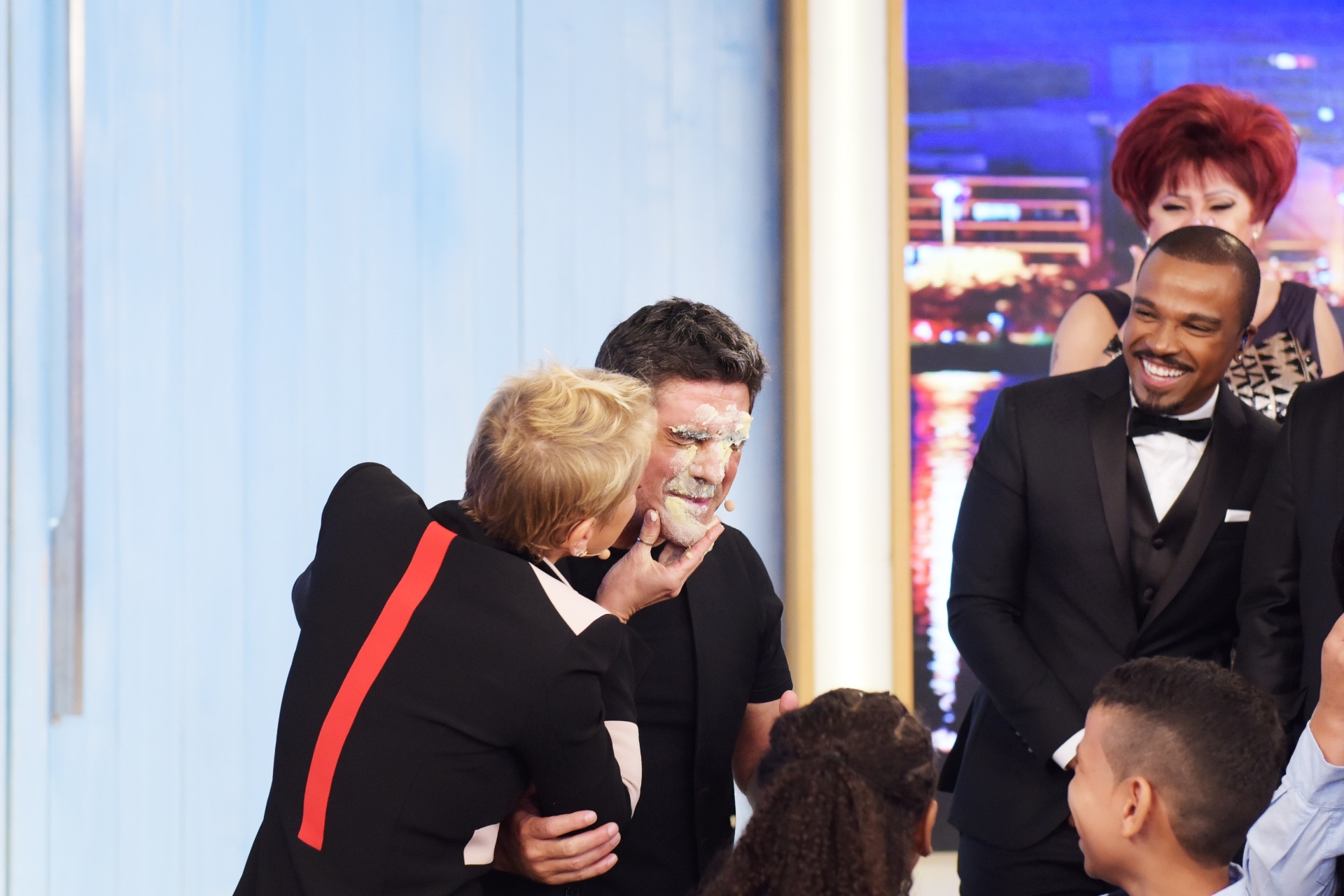 24.mar.2016- Xuxa lambuza Junno de bolo após cantar parabéns no palco do seu programa - Blad Meneghel/Divulgação