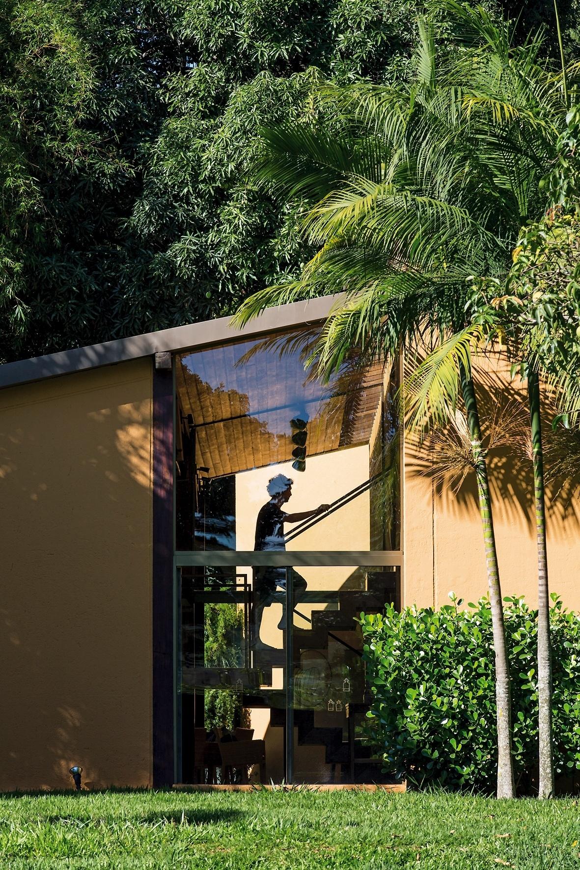 A escada de acesso aos dormitórios recebe luz natural através do recorte na lateral da fachada, com fechamento em vidro. A casa Várzea foi projetada pelo arquiteto Gustavo Penna e fica em Minas Gerais - undefined