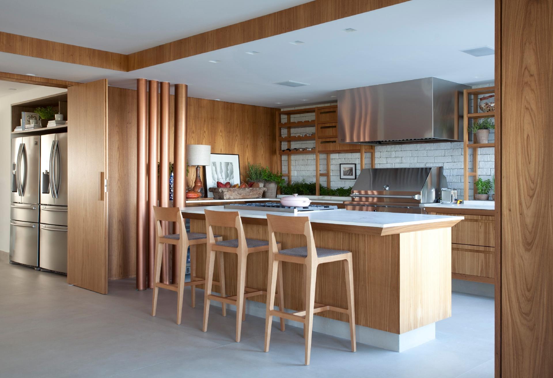 Sem barreiras com a sala e o living, a cozinha gourmet é o ponto predileto dos moradores. Mas ao remover as paredes, os arquitetos da Cipriano Paffi descobriram as tubulações de água do edifício, que não poderiam mudar de lugar. Entraram em cena os quatro tubos de PVC pintados de spray no tom cobre ? um de 5 polegadas e os demais de 3 polegadas ? que ainda trouxeram um clima industrial ao projeto - Marco Antonio | Divulgação