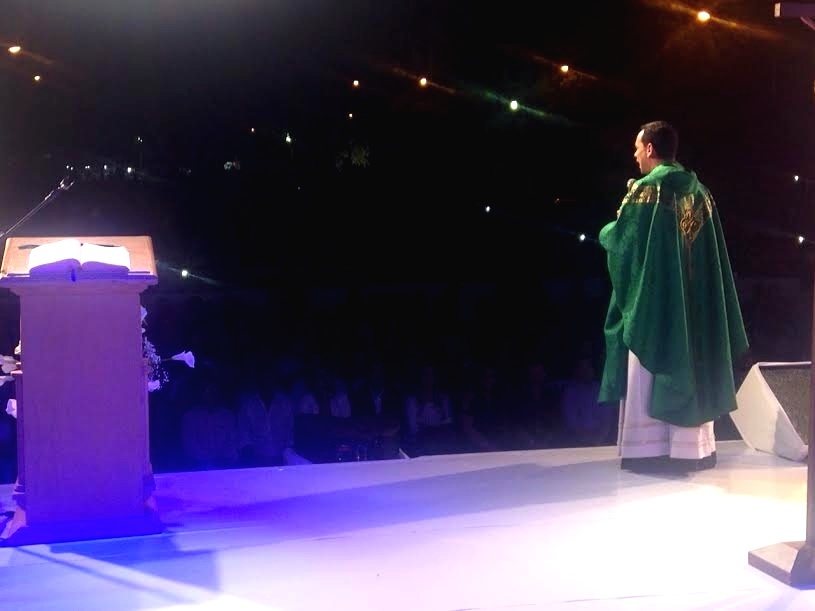 O padre Marcos Rogério, amigo de Cristiano Araújo, celebra a missa de sétimo dia do cantor em palco montado no estacionamento da paróquia - Luciana Vitorino/UOL