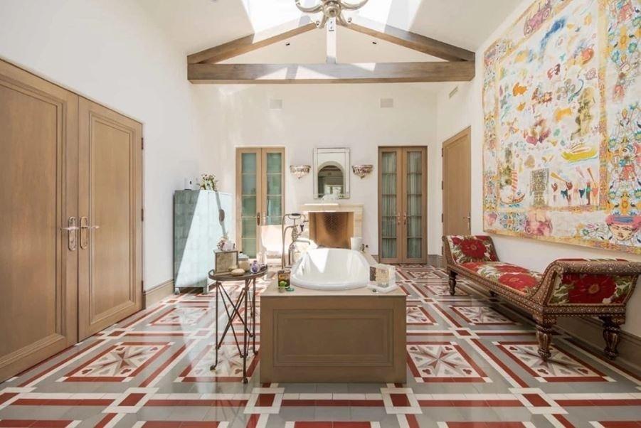 Em outro banheiro, obras de arte decoram o espaço, ocupado por uma banheira no centro - Douglas Elliman/Divulgação 