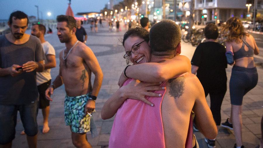 Jovens se abraçam em calçadão da praia em Tel Aviv, em Israel; após série de flexibilizações, país voltou a fazer apelos pelo distanciamento social - Amir Levy/Getty Images