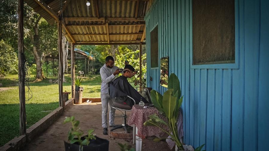 O barbeiro Flávio Mateus do Santo de Sousa cortando o cabelo de um cliente - Avener Prado/Mongabay