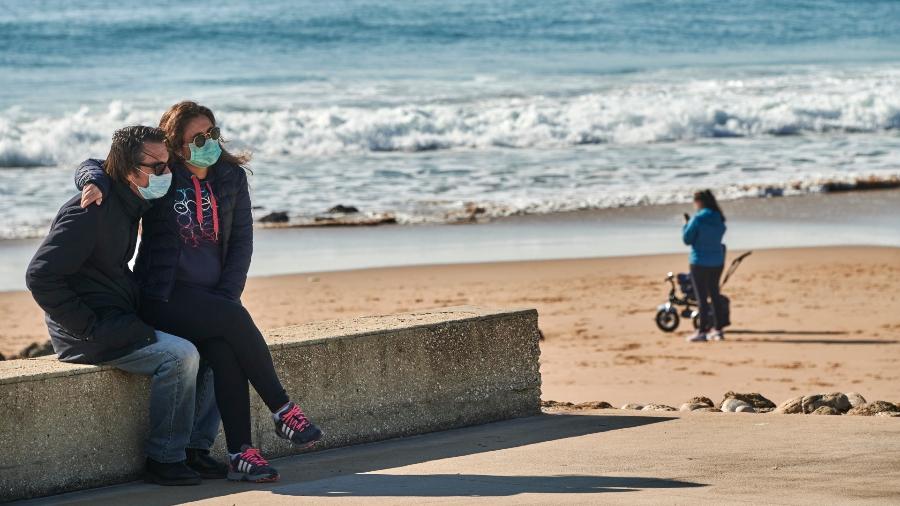 Casal usa máscaras em praia de Portugal - Getty Images