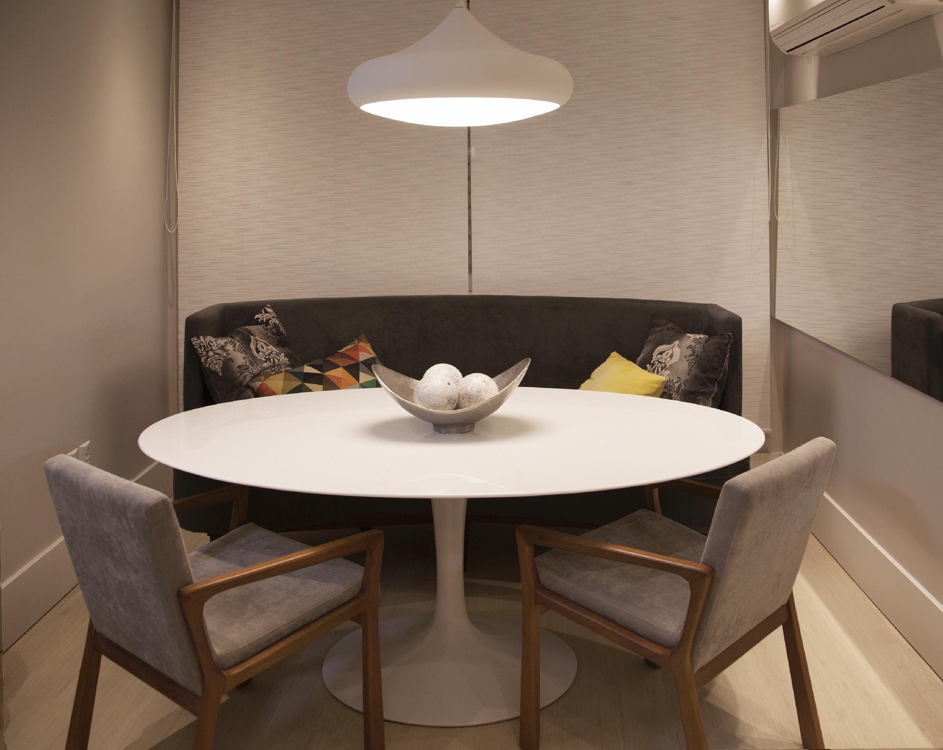 O conceito do projeto era utilizar o recuo na área social para criar uma sala de jantar com uma pegada de estar. Para acompanhar a mesa oval, Ligia Piccini, da Kali Arquitetura, apostou em um sofá especial para o projeto, que abraça a mesa, e com altura especial ? os moradores gostam de utilizá-la para trabalhar também. Para completar, duas cadeiras que lembram o conforto de uma poltrona - Yuri Ruppenthal/Divulgação