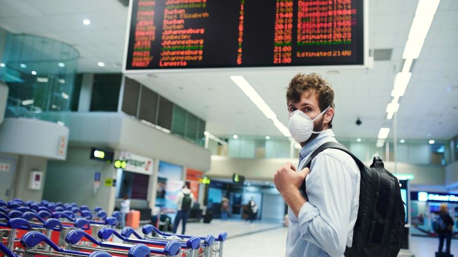 Homem usa máscara em aeroporto - Getty Images