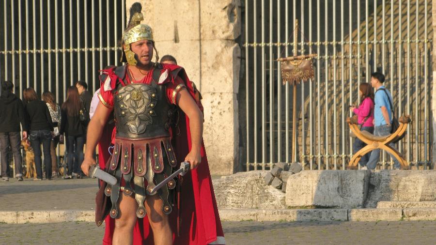 Imagem de 2021 de ator vestido de gladiador em frente ao Coliseu de Roma: atuação no local já havia sido proibida pela prefeitura - Getty Images