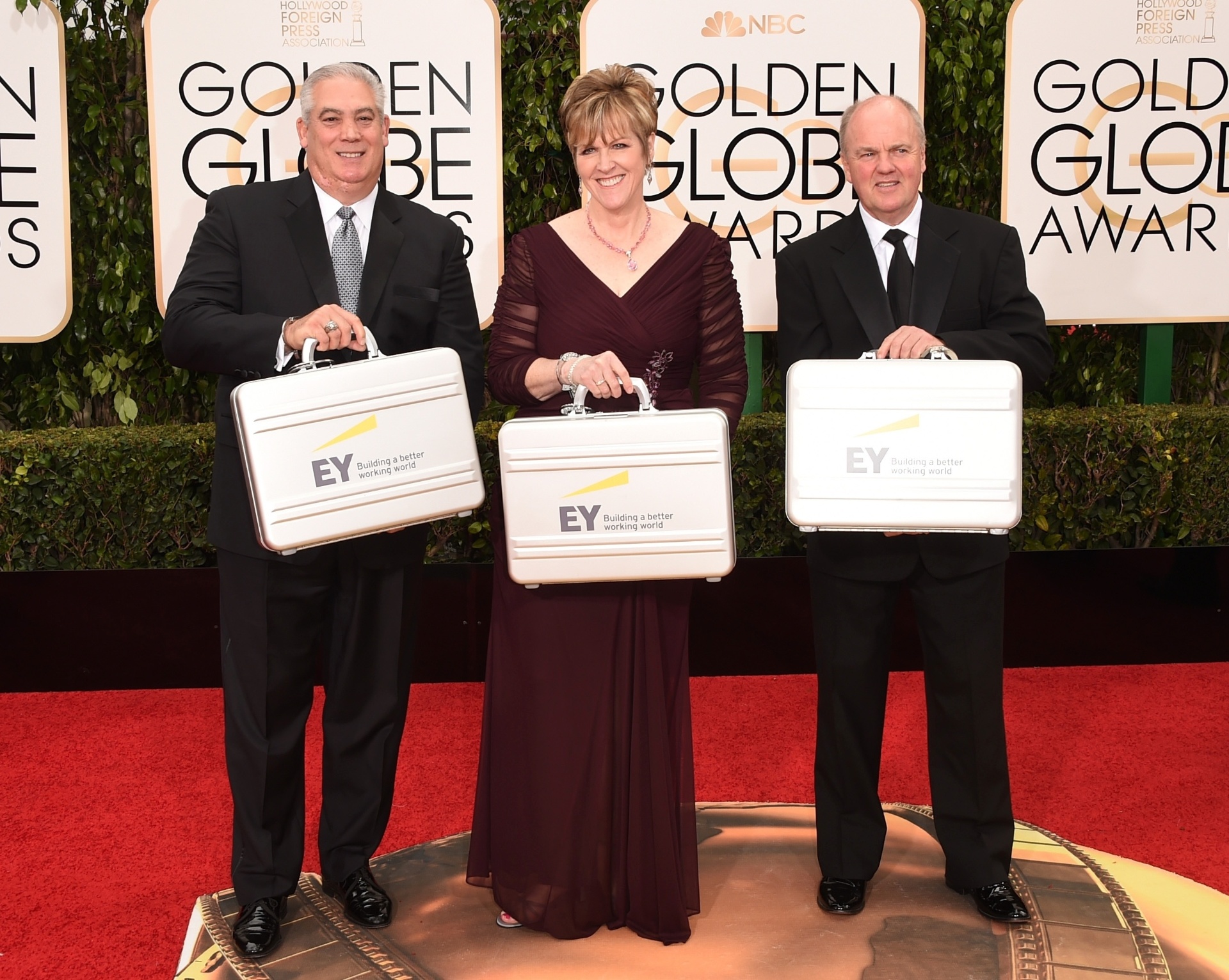Representantes da empresa de auditoria Ernst & Young carregam as maletas com os resultados dos vencedores do 73º Globo de Ouro. Eles posam para foto no Beverly Hilton Hotel, em Beverly Hills, na Califórnia - Getty Images