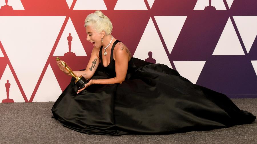 Lady Gaga admira o Oscar que ganhou de melhor canção por "Shallow", de "Nasce Uma Estrela" - Frazer Harrison/Getty Images