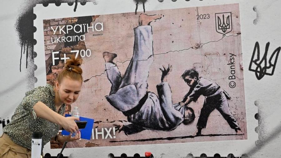 O grafiteiro britânico estampou um jovem judoca derrubando um homem adulto em um prédio próximo a Kiev, uma alegoria da Ucrânia derrotando a Rússia - AFP - SERGEI SUPINSKY