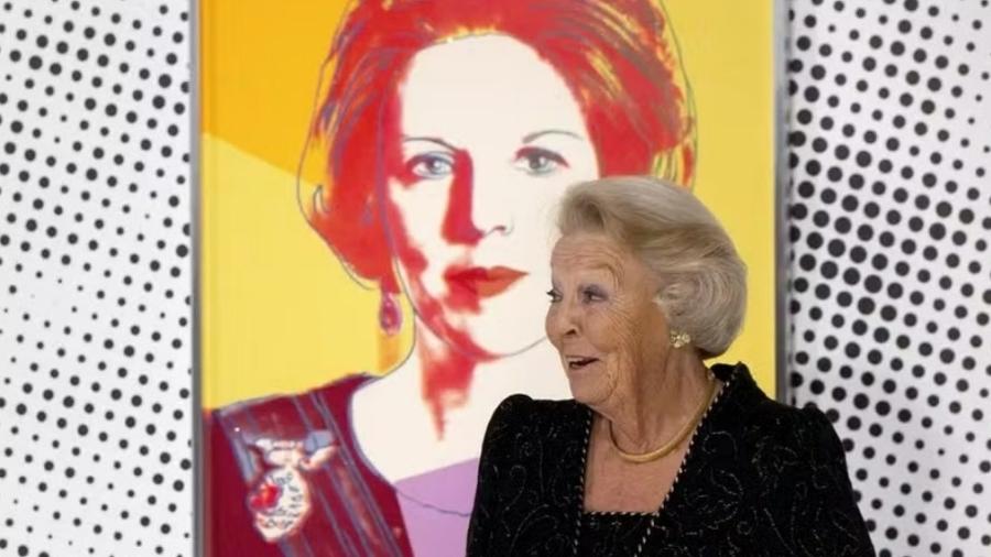 Beatriz da Holanda posa em frente ao seu retrato feito por Andy Warhol -  AFP