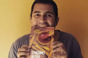 O escritor Henrique Rodrigues com seu livro "O Próximo da Fila" - Divulgação
