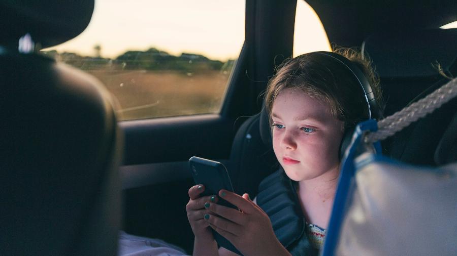 Criança no banco de trás não precisa segurar o celular ou tablet durante a viagem; deixe essa tarefa para um suporte - Getty Images
