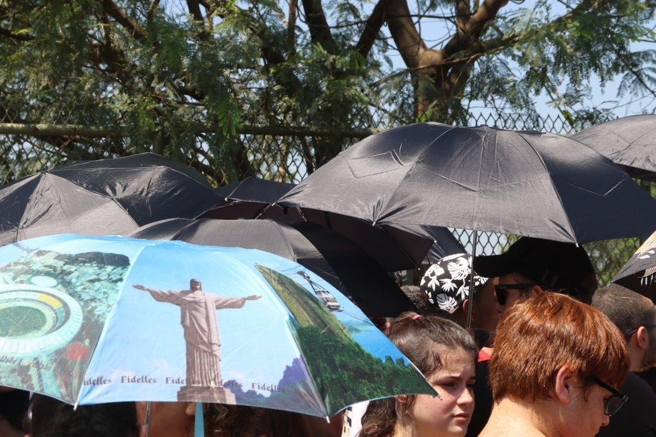 18.set.2015- Fãs se protegem do sol e do calor na entrada da Cidade do Rock - Zulmair Rocha/UOL