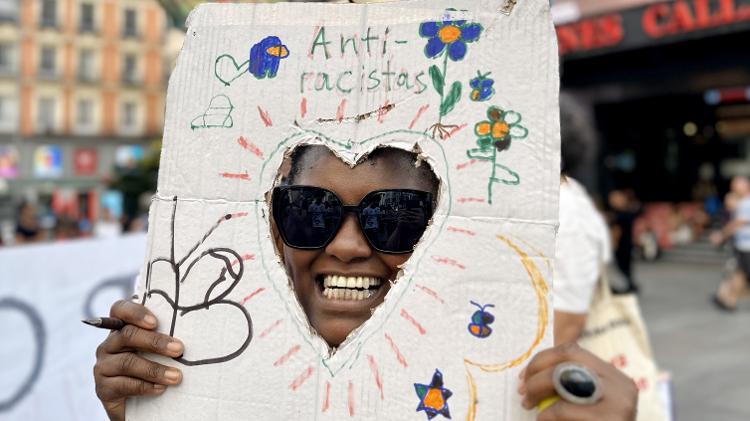 Maria dos Santos, ativista durante manifestação em Madri com arte feita pelo proprio filho - Natália de Oliveira Ramos/ysoke - Natália de Oliveira Ramos/UOL