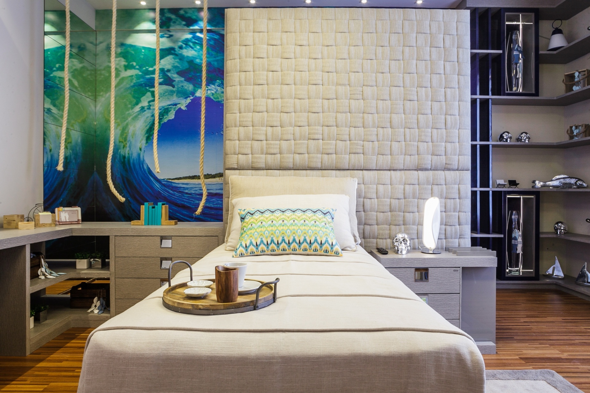 1 - Quarto do surfista. No ambiente projetado pela arquiteta Hellen Caroline Giacomitti, um único móvel forma a bancada, o criado-mudo e a cabeceira. No espaço pensado para um jovem solteiro que curte pegar ondas, o painel fotográfico e outras peças decorativas remetem ao mar. A Casa Cor Paraná fica em cartaz até dia 9 de agosto de 2015, na Rua Fernando Amaro, 60, em Curitiba. Outras informações: www.casacor.com.br - Daniel Sorrentino/ Divulgação