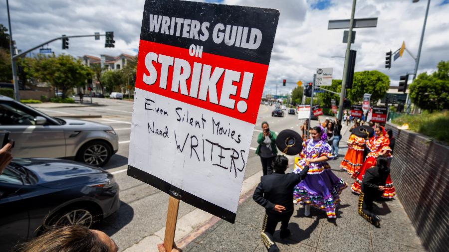 Roteiristas protestam em frente à Universal Studios, em Los Angeles. "Até o cinema mudo precisa de roteiristas" - Hans Gutknecht/MediaNews Group/Los Angeles Daily News via Getty Images