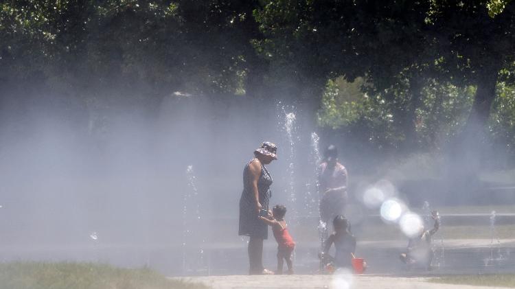 Pessoas se refrescam em uma fonte em parque de Madri durante uma onda de calor em julho