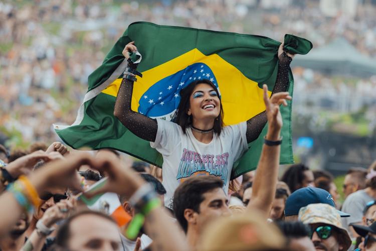 Garota ergue a bandeira brasileira no festival Tomorrowland 2024, em Boom, na Bélgica