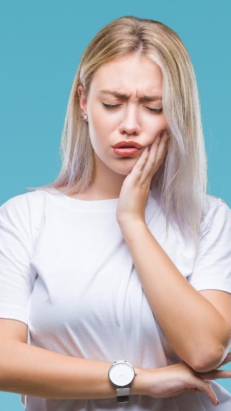 mulher com dor na boca - iStock - iStock