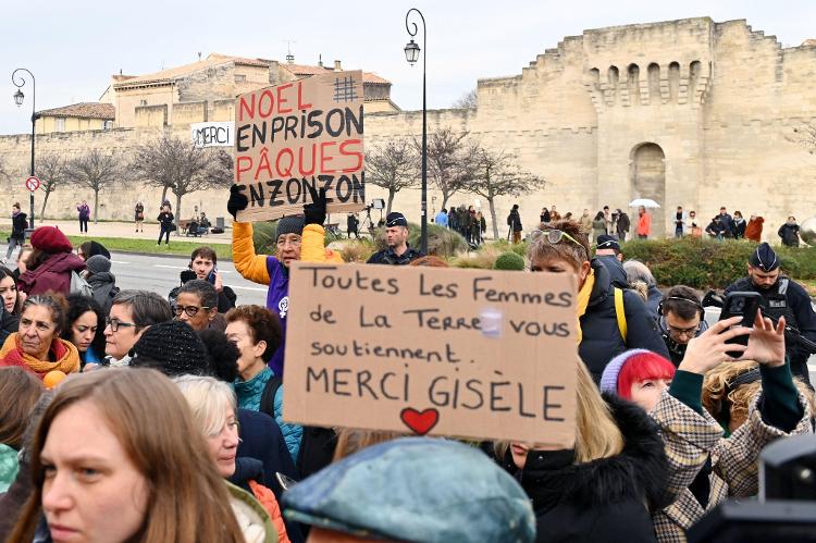 Pessoas seguram cartazes em frente ao tribunal de Avignon, na França, em 19 de dezembro de 2024, com o dizeres: 'Natal na prisão, Páscoa na prisão' e 'Todas as mulheres do mundo apoiam você, obrigada, Gisèle' 