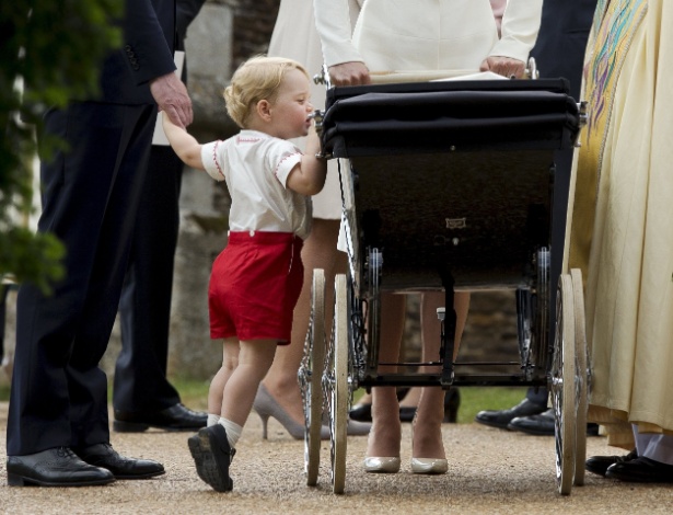 5.jul.2015 - Príncipe George espia carrinho da irmã, a pequena Charlotte, após o batizado dela na igreja Santa Maria Madalena, em Sandringham, na Inglaterra.