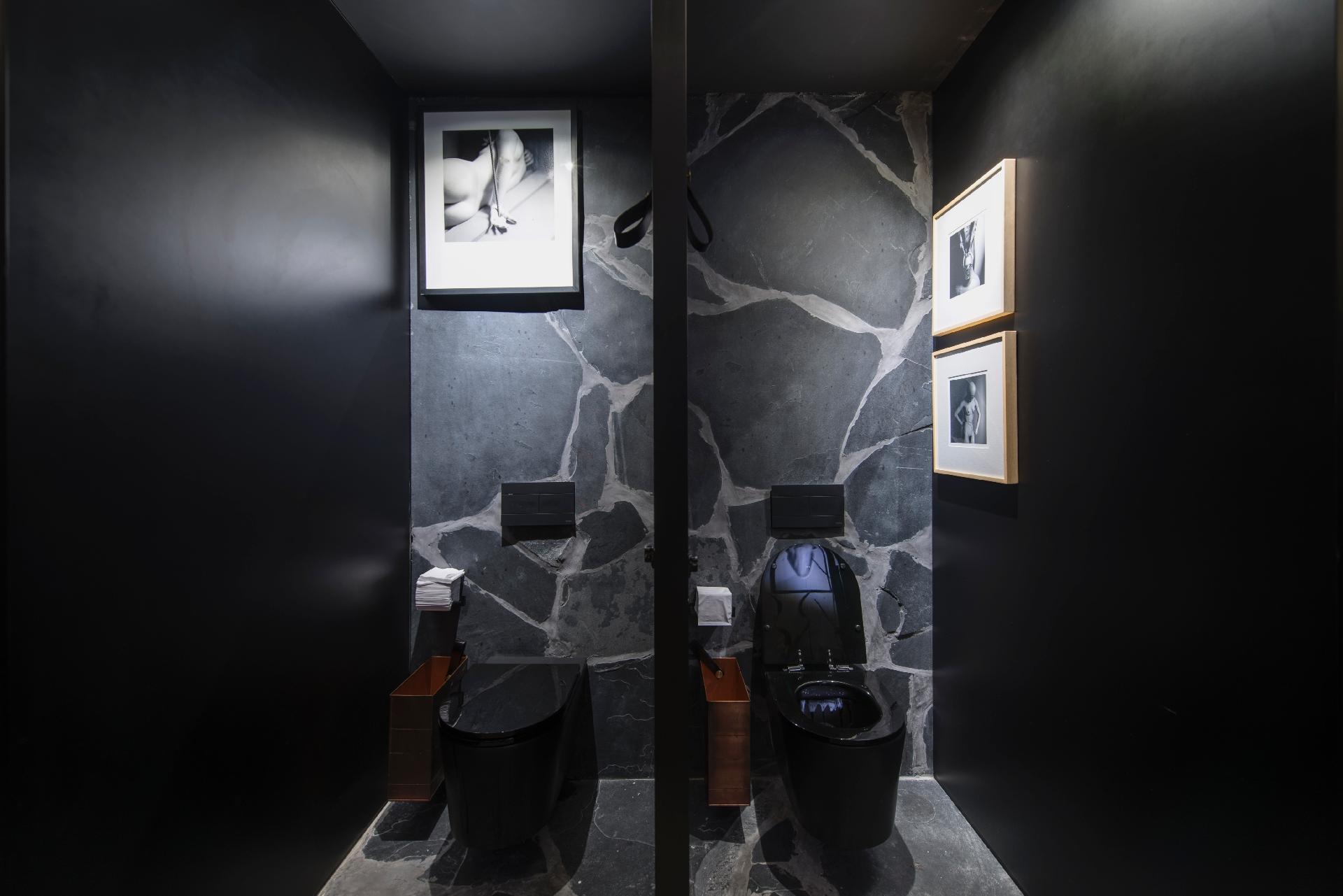 As louças pretas suspensas estão em uso no Banheiro Unissex, assinado por Gustavo Neves, na Casa Cor SP. Ao fundo a parede recebeu placas de ardósia com formatos orgânicos. As fotografias que decoram as cabines são do fotógrafo de moda Ivan Erick Menezes (www.ivanerick.com) - Katia Kuwabara/UOL