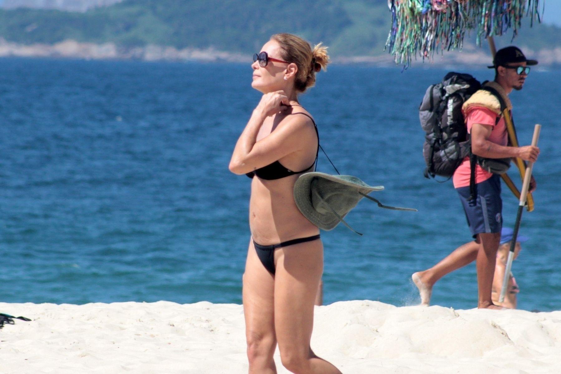 Carolina chamou a atenção dos banhistas ao exibir um corpo sarado. O biquíni preto simples ressaltou ainda mais a sua boa forma aos 50 anos completos em janeiro  - Agnews