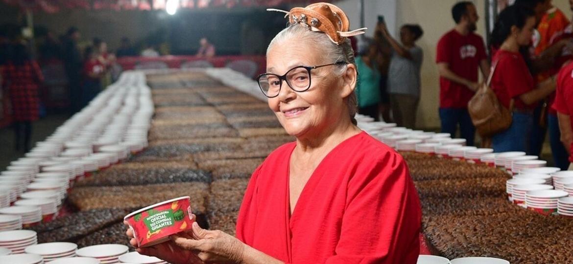 Dona Maria do Bolo, a criadora do maior pé de moleque do mundo, em Caruaru. Atrás dela, o bolo de 20 metros e mais de uma tonelada - Ademar Filho