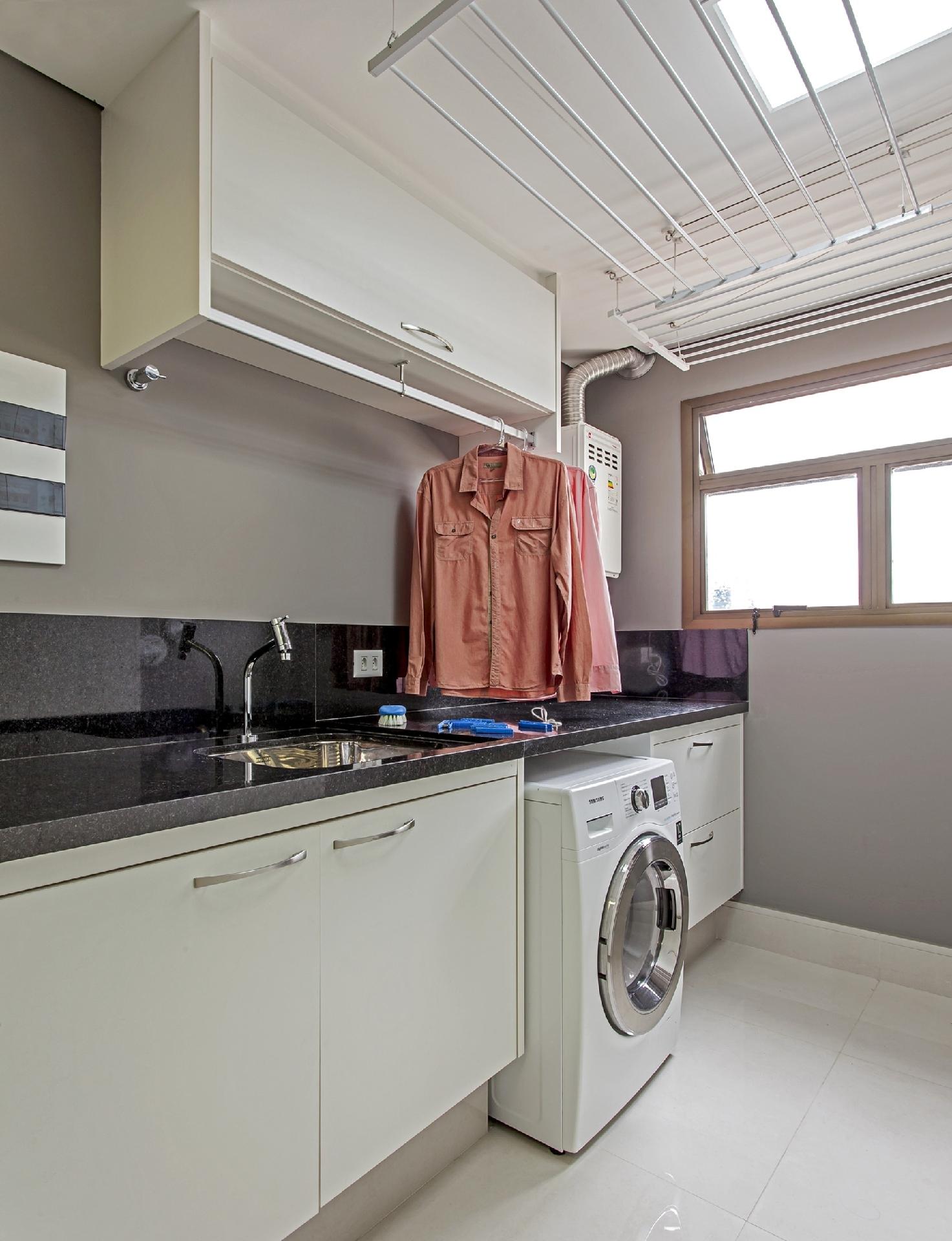 Organização é a palavra de ordem deste projeto da arquiteta Cristiane Schiavoni. Sobre a bancada, o armário com cabide possibilita pendurar as roupas passadas até que sejam levadas ao closet. Ao lado da máquina lava e seca, perfeita para economizar espaço, está a dupla de gavetas, uma para roupas limpas e outras para as sujas - Carlos Piratininga | Divulgação