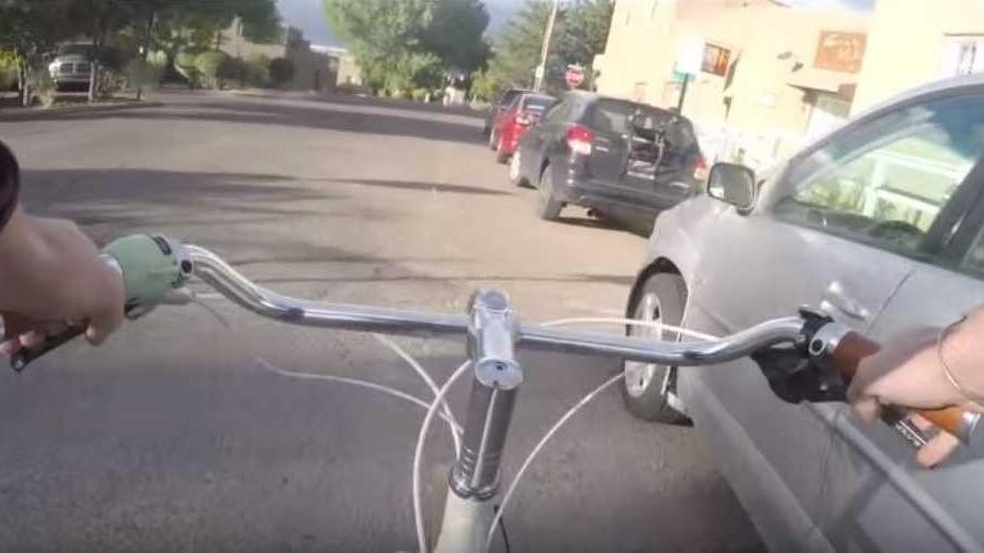 Ciclista se desloca ao lado de automóveis estacionados: cena comum e que pode resultar em acidentes - Reprodução