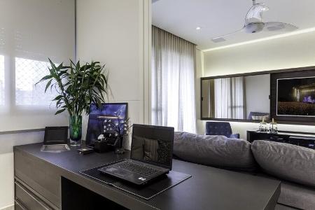 Neste projeto assinado pela arquiteta Cristiane Schiavoni, o cliente decidiu pelo seu home office próximo à sala de estar, já que gosta de exercer suas atividades profissionais enquanto assiste televisão. Assim, para esconder sua ?bagunça? de trabalho, as portas de correr fazem a divisão entre os ambientes - Carlos Piratininga - Carlos Piratininga