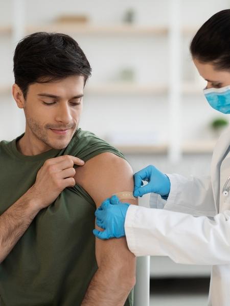 Homem recebendo curativo após ser vacinado