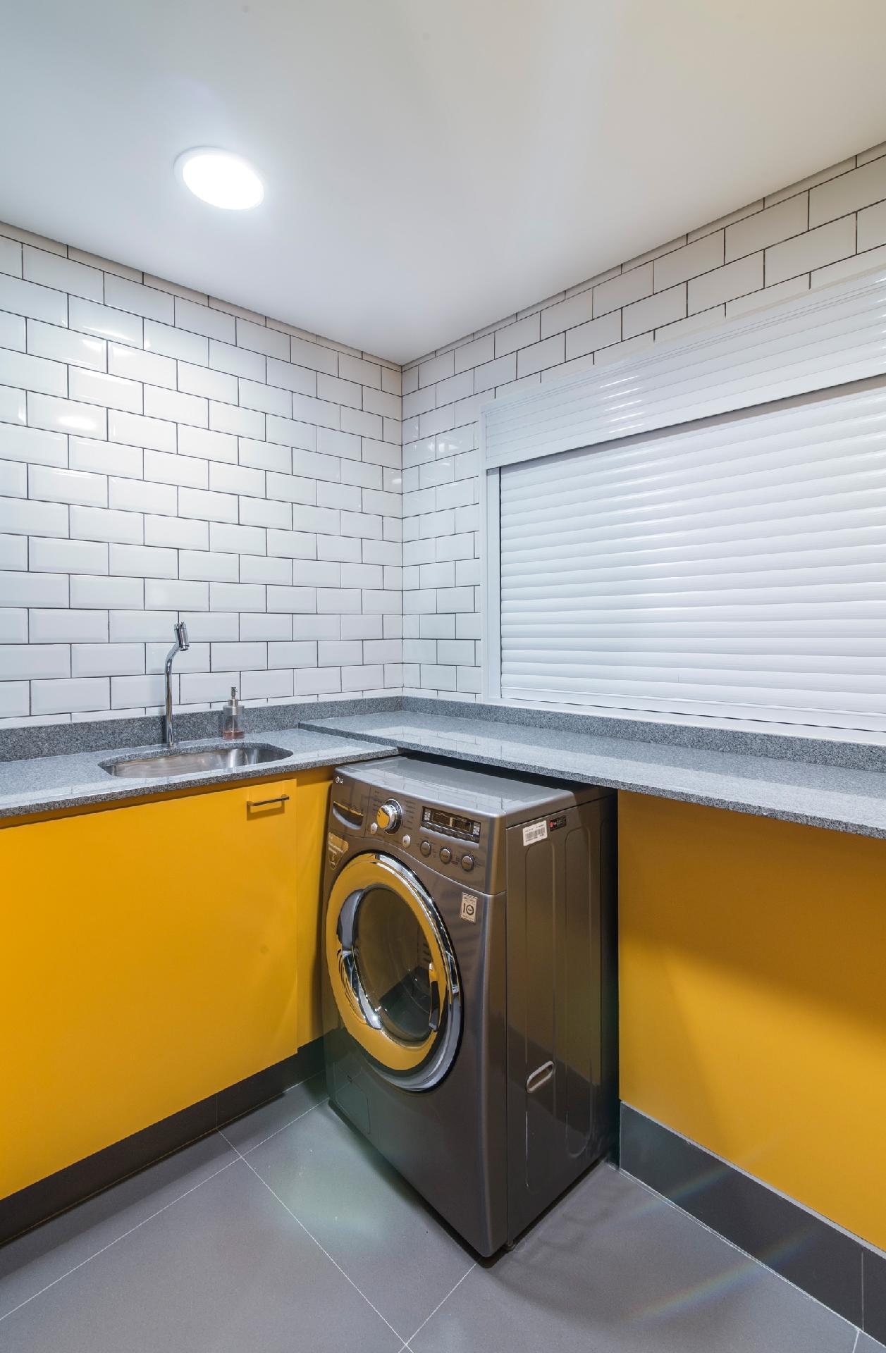 Sim, uma lavanderia também pode ser colorida e lúdica. Essa é a proposta do arquiteto Pietro Terlizzi, que jogou com marcenaria mostarda e usou cerâmicas brancas, como as dos metros de Londres e Nova Iorque, nas paredes - Guilherme Pucci | Divulgação