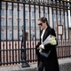 Mulher chega com flores no Palácio de Buckingham após o anúncio da morte do príncipe Philip - TOLGA AKMEN / AFP