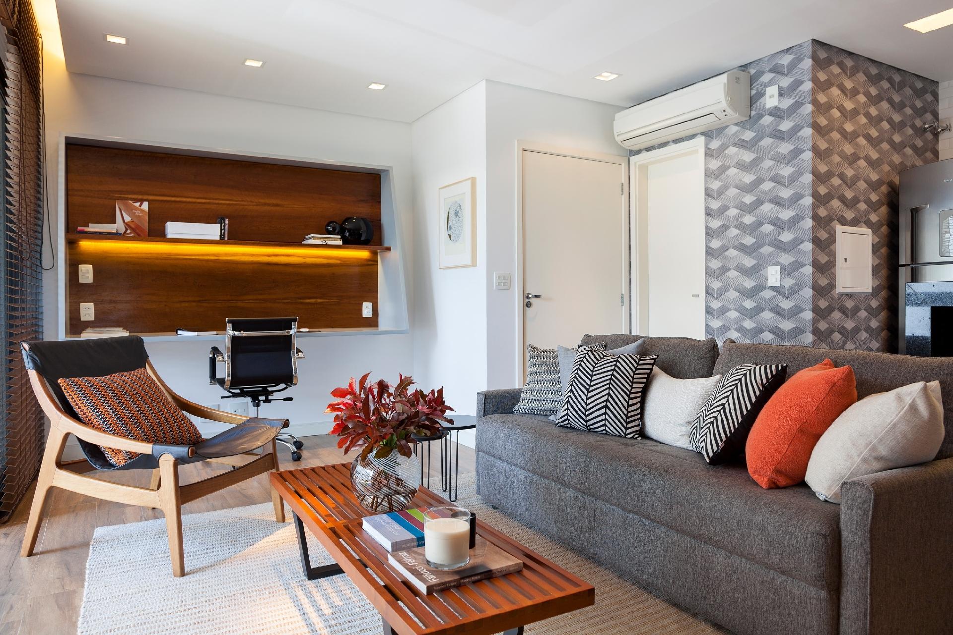 Contíguo ao living, o pequeno escritório vira o destaque da decoração quando está de luzes acesas. Os profissionais da Ah!Sim usaram fitas de led tanto na prateleira de madeira como no rasgo rente à persiana. Suave, essa iluminação dá um clima aconchegante ao ambiente - Julia Ribeiro/Divulgação