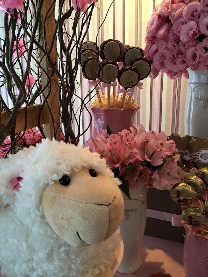 Atrás da ovelha de pelúcia, vaso de louça rosa com pirulitos de brigadeiro e arranjo grande de lisiantus rosa em vaso de louça branco. Do lado direito, vaso de louça rosa com pirulitos de biscoito da chef Aline Leone enfeitavam este chá de fraldas - Divulgação