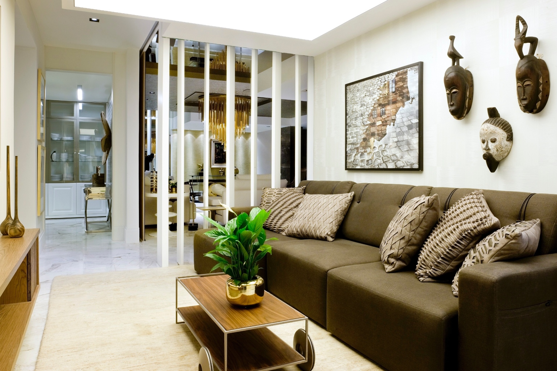 No projeto Luxo Urbano, do Studio Denise Zuba, a parede deu lugar aos painéis pivotantes de madeira laqueada, que delimitam, mas também integram, o home theater (foto) à sala de estar (ao fundo). Quando os usuários querem privacidade, porém, a estrutura pode ser completamente fechada | A Casa Cor Brasília (www.casacor.com.br) fica em cartaz até 10 de novembro de 2015 - Edgard César/ Divulgação