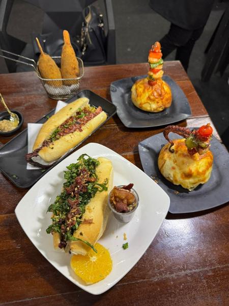 Além de caldos, Rosi também vende picolé de siri- um petisco frito, modelado em formato de picolé; pão de alho cremoso com recheio de camarão e o cachorro-quente de polvo, Além de caldos, Rosi também vende picolé de siri- um petisco frito, modelado em formato de picolé; pão de alho cremoso com recheio de camarão e o cachorro-quente de polvo,
