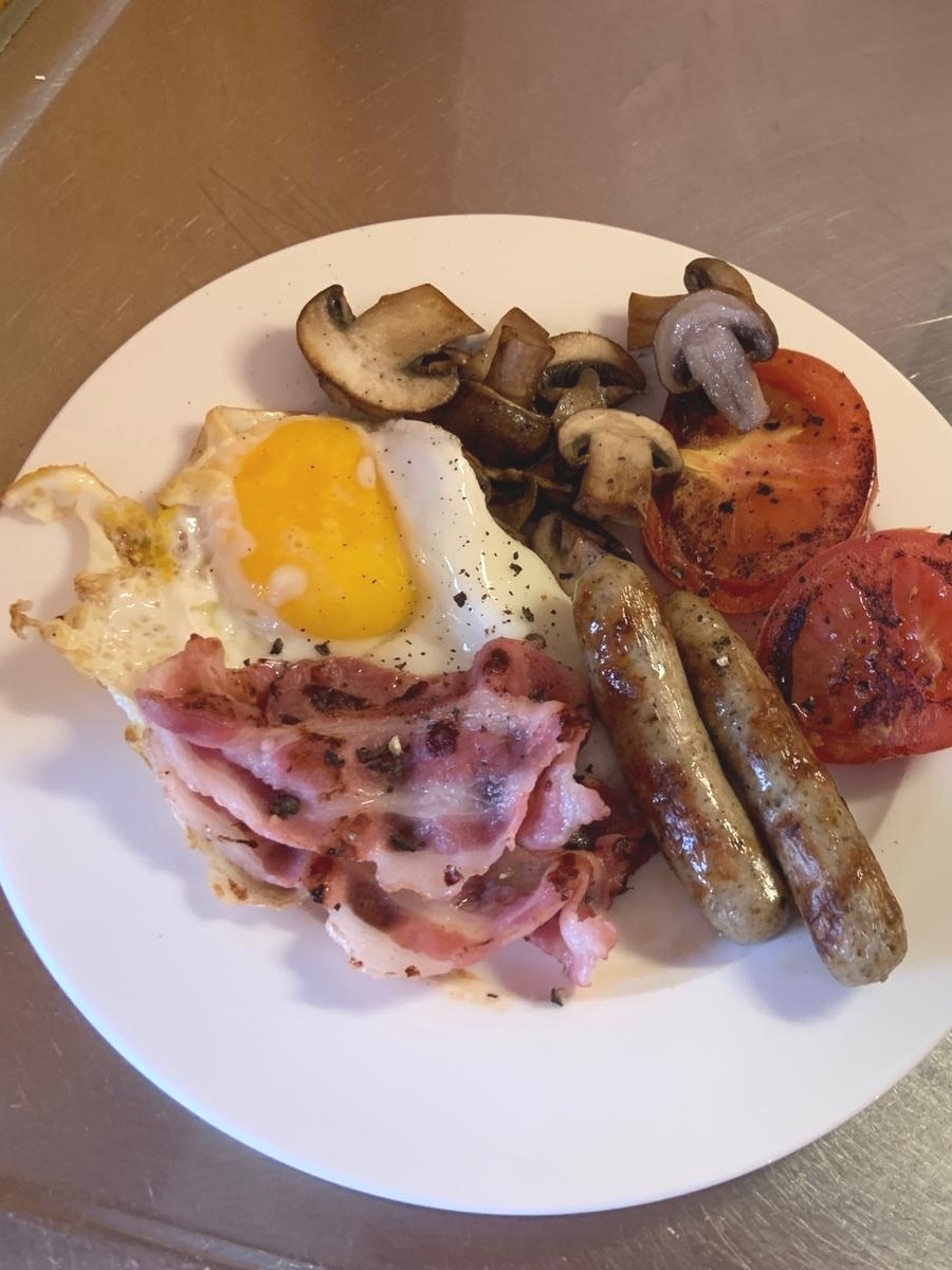 Café da manhã inglês com ovos fritos, bacon, queijo, tomate no