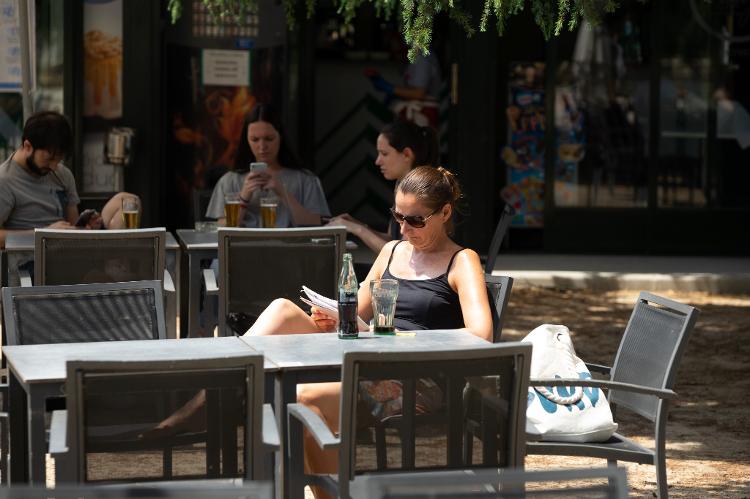 Mulher senta sozinha em mesa de restaurante em Madri, Espanha