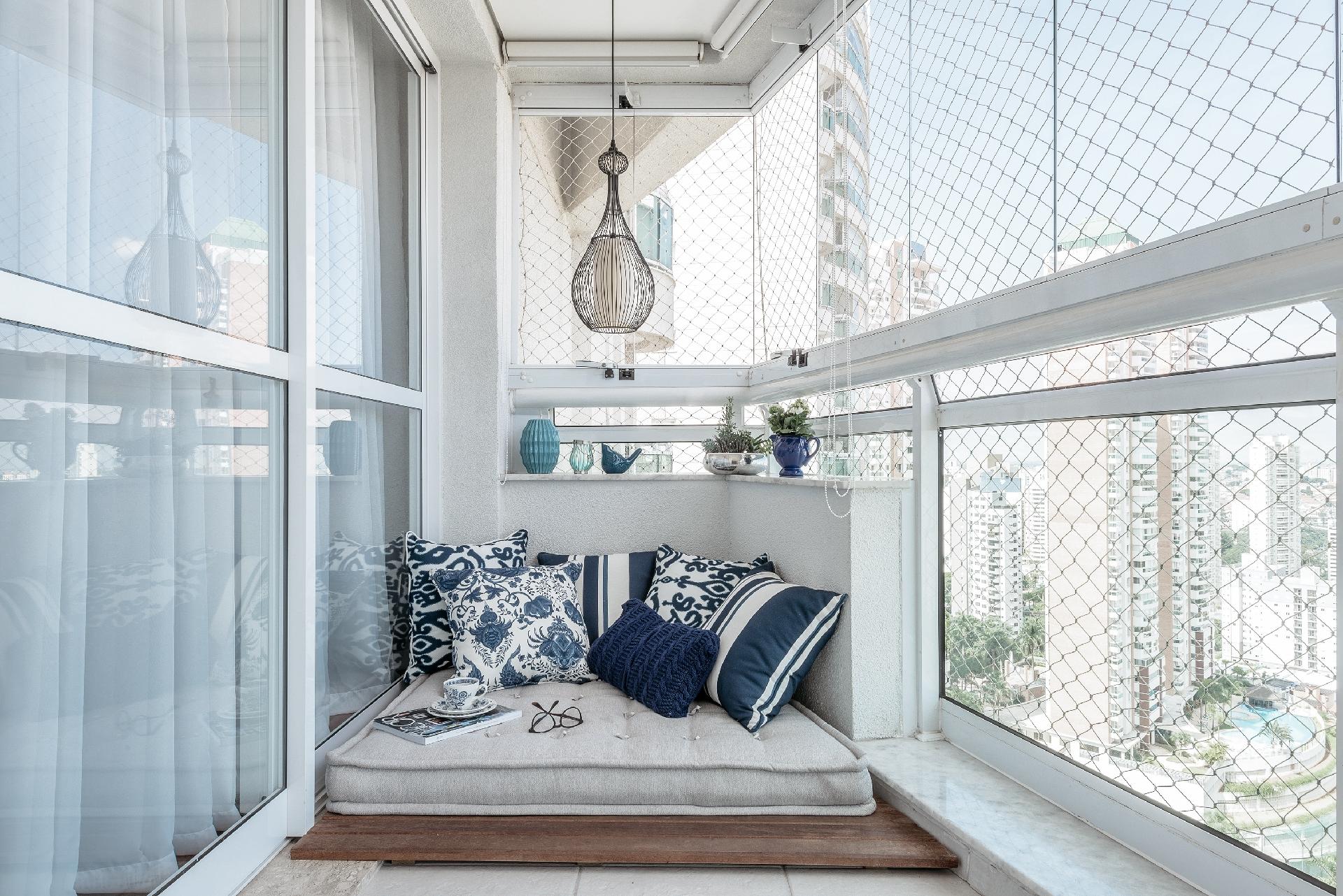 A pequena sacada tinha um canto estreito cujo meio muro limitava o uso do local. Foi então que a designer de interiores Erika Tofani teve a ideia de transformá-lo em um delicioso espaço de leitura e descanso. Para isso, usou um deque de madeira e um futon sob medida, protegido pelo fechamento de vidro do guarda-corpo - Favaro Jr. / Divulgação