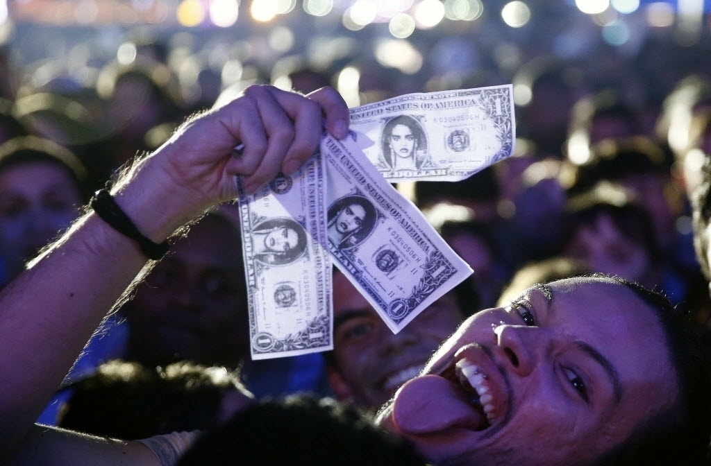 26.set.2015 - Fãs de Rihanna aguardam o início do show da cantora com notas de dólares com o rosto da diva pop - Marcelo Sayão/EFE