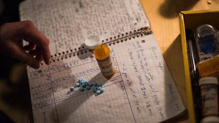 Jessica Falstein com suas pílulas e caderno para controle de dosagem - Joshua Bright/The New York Times
