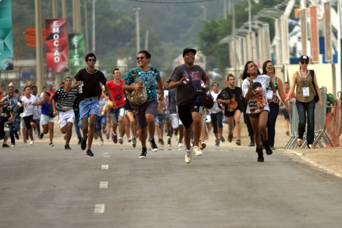26.set.2015 - Correndo para pegar melhores lugares para assistir seus ídolos, fãs que chegaram cedo entram na Cidade do Rock para o sexto dia de shows do Rock in Rio 2015. - Marcos Ferreira/Foto Rio News